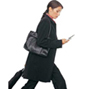 Woman walking with mobile phone and luggage