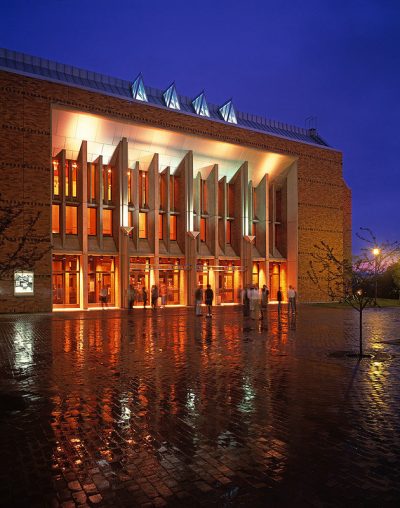 Exterior of a performaning arts center at night, bright lit.