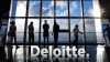 Silhouettes of five people standing in front of a large window with a blue sky outside. White text below reads "Deloitte."