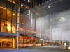 Main entrance to a brightly lit performance hall at night, with a hanging art installation out front made of mesh and lights.