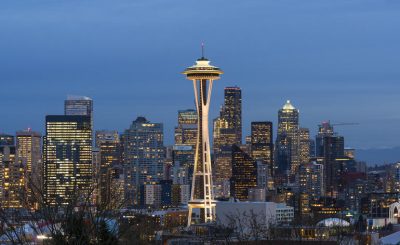 Seattle city skyline at dawn, the Space Needle brightly lit in the center.