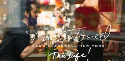 Two people drinking coffee in a cafe. Text across image reads "Marc Blackwell New York; This Life!"