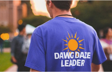 View of a student from behind; they are wearing a purple tshirt that reads "Dawg Daze Leader."