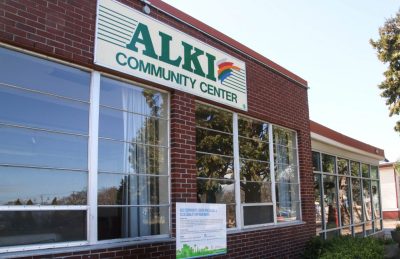 Red brick building with large windows, and a sign near the top that reads "Alki Community Center."