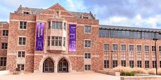Modern brick university building featuring two purple banners hung on the outside.