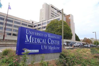 a hospital with a blue sign out front that reads, "University of Washington, Medical Center, UW Medicine"