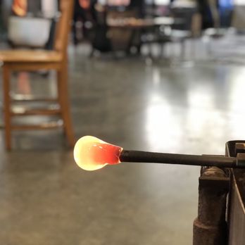 Ball of molten hot glass at the end of a glass blowing pipe.