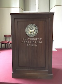 Meeting room podium, with University of Turin seal.