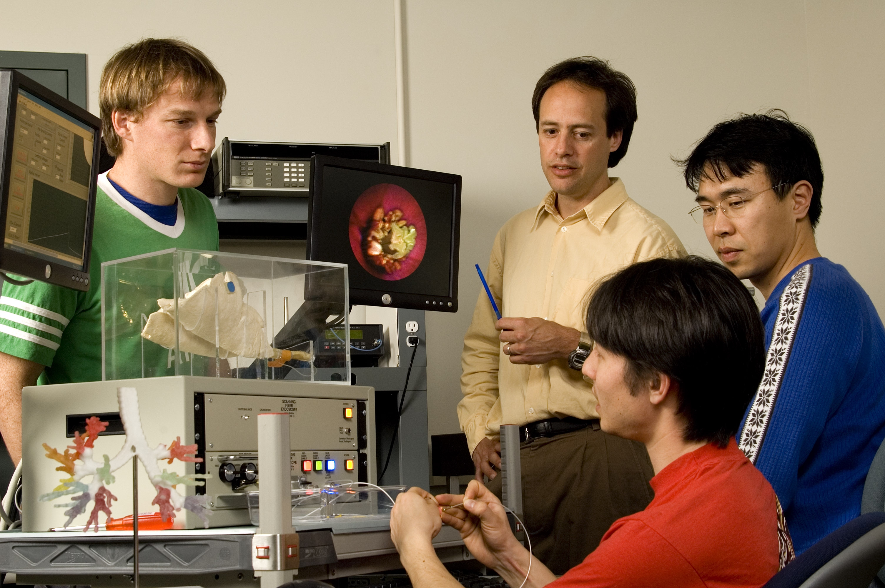 Engineering faculty member and three students in a lab setting