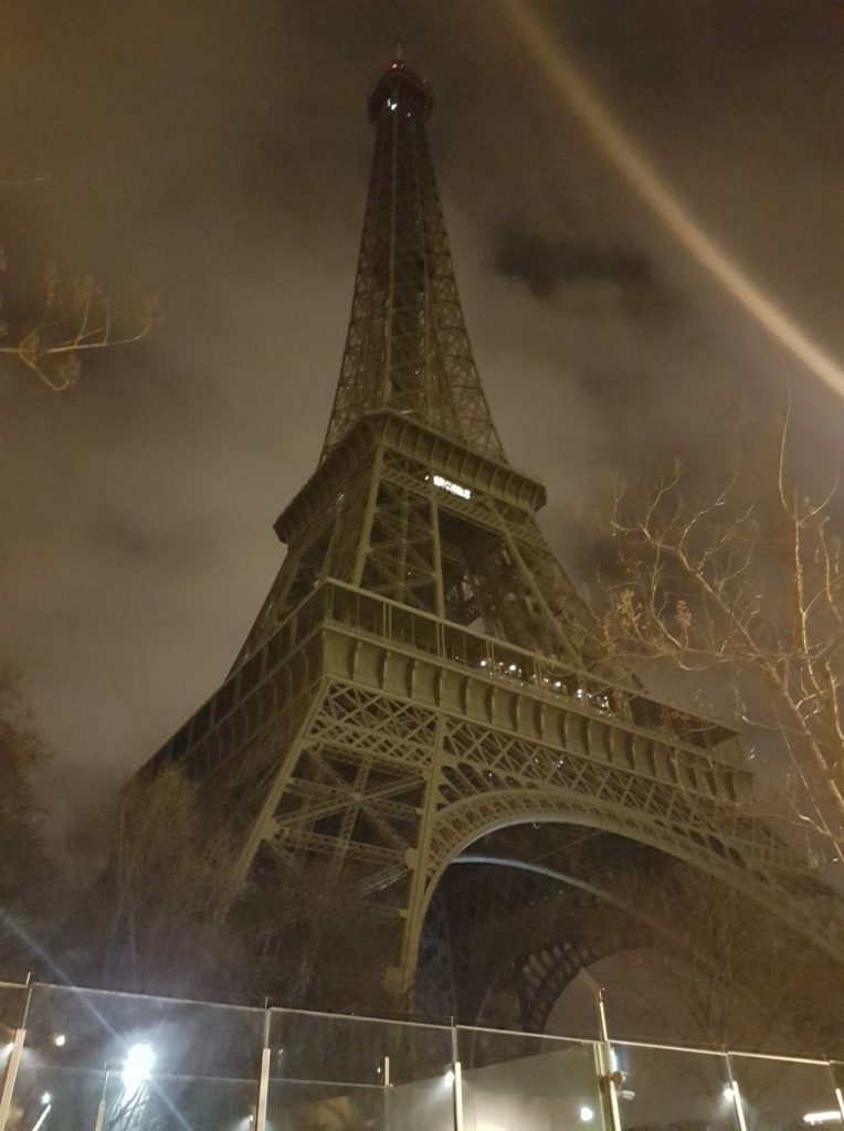 Eiffel Tour at night, surrounded by fog and wire fencing