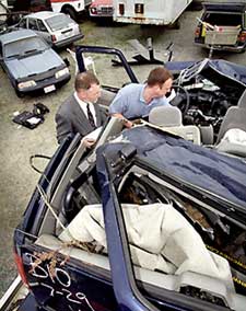 Charles Mock examines wrecked car