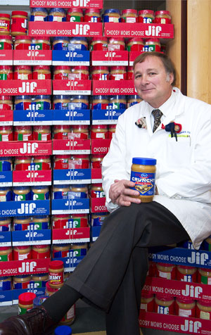 photo of Patch Dellinger in front of a stack of peanut butter