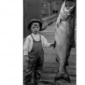 Small boy standing next to salmon catch, Pacific Northwest