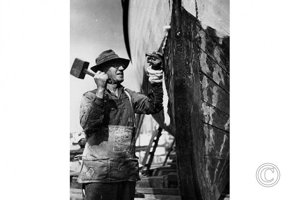 Workman repairing hull of boat_ Seattle_ Washington_ ca_ 1940 