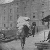 Chinese dock worker loading 50lb bags of flour