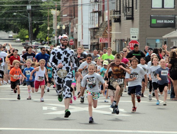 Incoming MEDEX student Mike Carter kicks off the 1-Mile Kids Run in a cow suit.