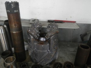 A rotary drill bit (center), two APC barrels (far left), an XCB (extended core barrel, just to the left of the bit), and several core catchers (front).