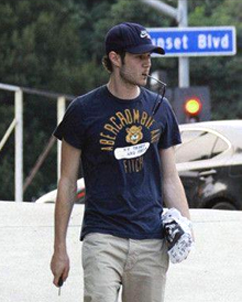 This is the image of a young man who is walking down the street, wearing an Abercrombie T-shirt.