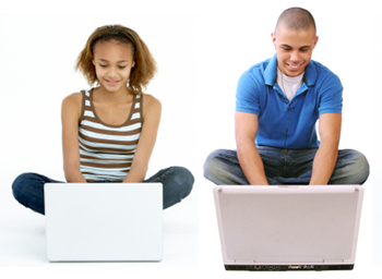 A teen girl and boy are sitting side by side on the floor, each looking at their laptop computers.