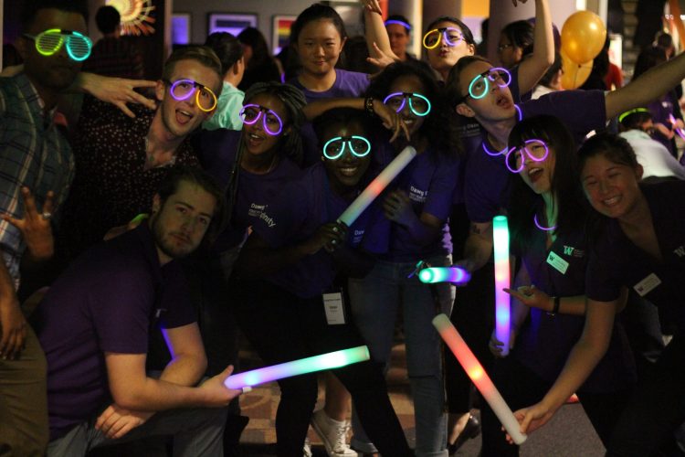 Group of students wearing glow in the dark accessories posing for a picture at a previous Block Party event