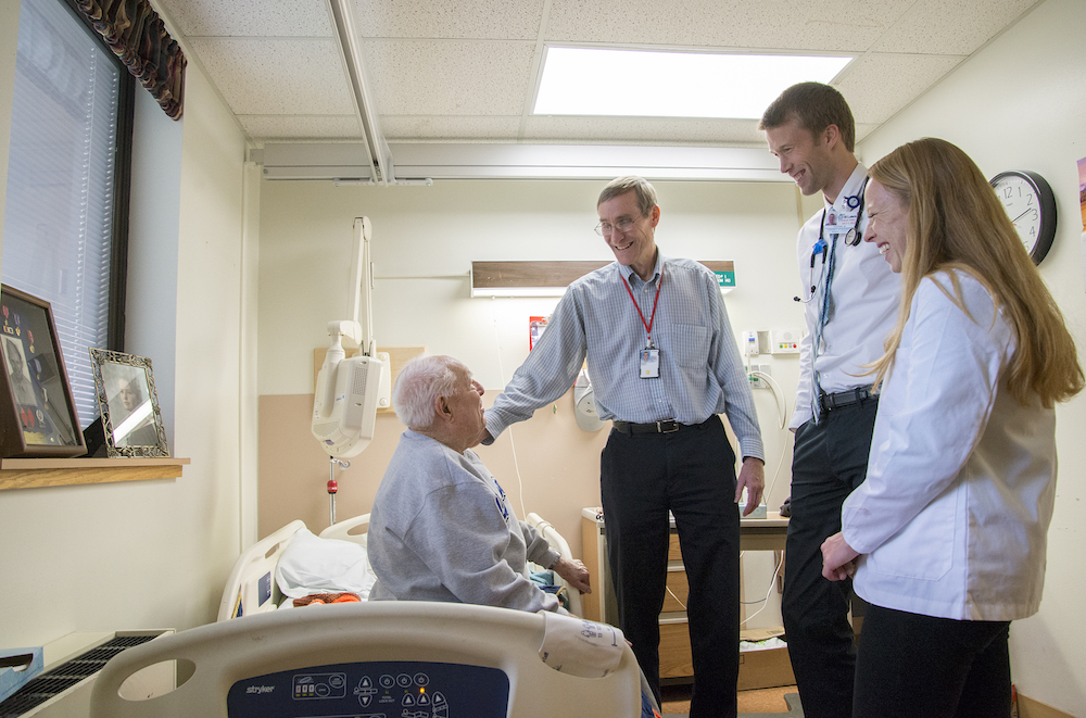 Dr. James Branahl (center left), WWAMI instructor, general adult medicine and geriatric medicine, advising fourth-year medical students with patient during rounds at the Boise VA Medical Center.