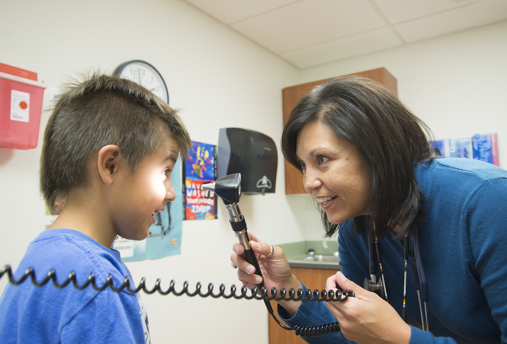 Dr. LeeAnna Muzquiz, WWAMI instructor, family medicine, performing physical exam on child patient at the Tribal Health Clinic in Polson, MT.