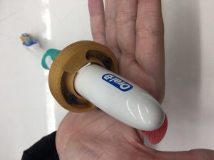 3D printed piece wrapped around toothbrush which the user holds to the camera