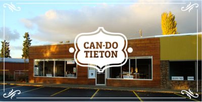 Exterior of an art center building, painted orange and yellow. White logo with text that reads "Can Do Tieton."