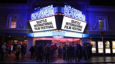 Brightly lit theater marquee in neon reading "SIFF cinema uptown: seattle international film festival"