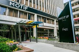 Exterior entrance of a hotel, a sign reading "MOTIF" over the awning.