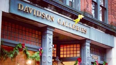 brightly lit storefront with festive holiday decor, metal signage reading "Davidson Galleries"
