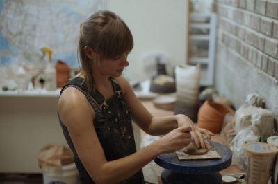 an individual works with clay in a ceramics studio
