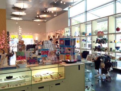 a brightly lit retail setting with large windows and many shelves and display cases.