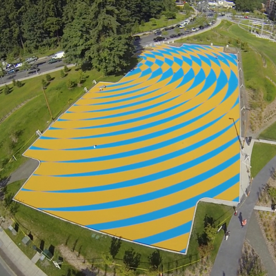 Aerial view of a parking lot painted with a blue and yellow optical art pattern.