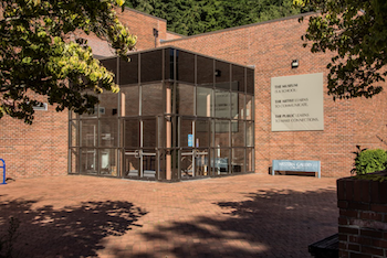 Brick university building featuring an all-glass vestibule entrance.