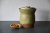 Handmade light green ceramic fermenting jar.