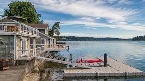 A bayside house with a ramp leading down to a dock in the water.