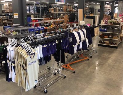 Retail warehouse sales floor with a display of University of Washington branded clothing.