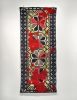 red, black, white, and yellow woven textile with floral and geometric patterns