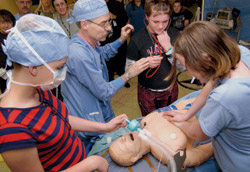 Young visitors to the UW Health Sciences Center Open House test their CPR skills on the anesthesia mannequin.