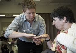 Student performing an exam on a patients hand
