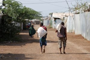 Men carry bags of food aid at the Kakuma refugee camp in northern Kenya, March 6, 2018. Picture taken March 6, 2018. REUTERS/Baz Ratner