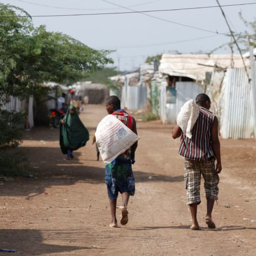 Men carry bags of food aid at the Kakuma refugee camp in northern Kenya, March 6, 2018. Picture taken March 6, 2018. REUTERS/Baz Ratner