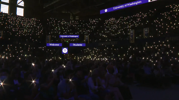UW Convocation audience lights up the arena with flashlights.