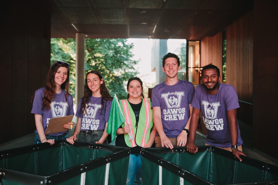 Photo of 5 DAWGS Crew volunteers standing with move-in carts in front of Elm Hall.