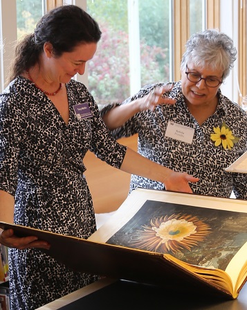 Tracy Mehlin discusses a rare book with local artist Sylvia Portillo