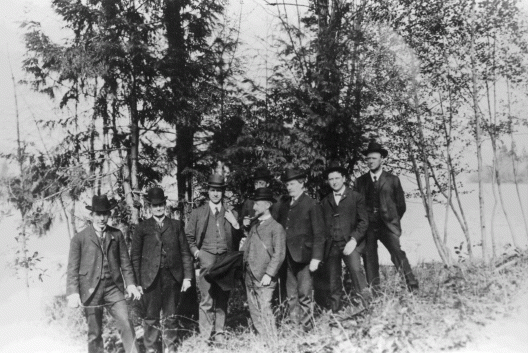 group of men posing in front of trees