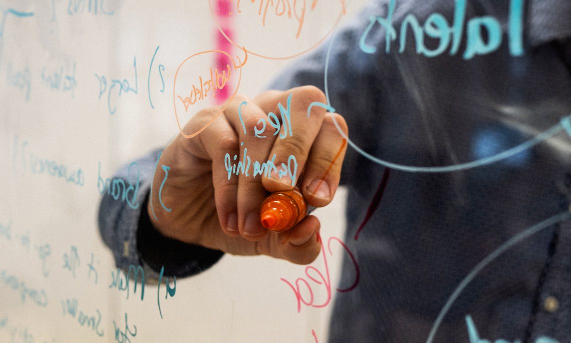 white hand writing on a clear board