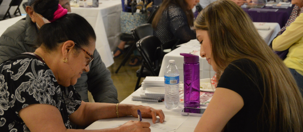 Three people gather around a table for cognitive testing at the Brain Health and Community Resource Fair.
