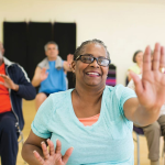 Diverse older adults exercise in a fitness class.